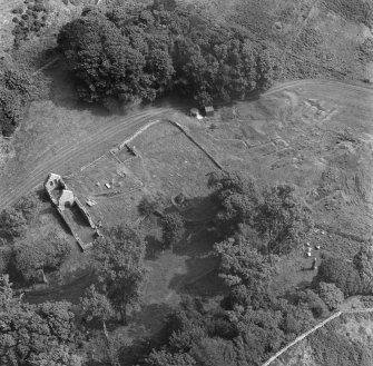Oblique aerial view centred on the remains of St Blane's Church and burial ground, Bute, taken from the WNW.