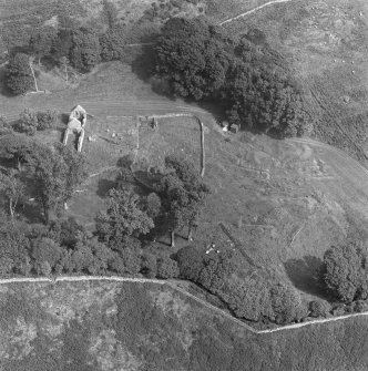 Oblique aerial view centred on the remains of St Blane's Church and burial ground, Bute, taken from the N.