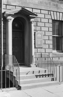 View of the front door of 6 Buccleuch Place, Edinburgh with two Doric columns supporting an open pediment 
seen from the north.