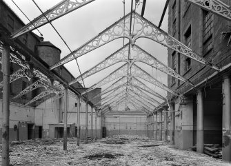 Interior view of Ward Mills, Dundee showing ornate cast iron trusses during demolition.
