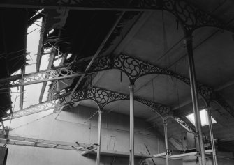 Interior view of Ward Mills, Dundee showing detail of ornate cast iron trusses during demolition.