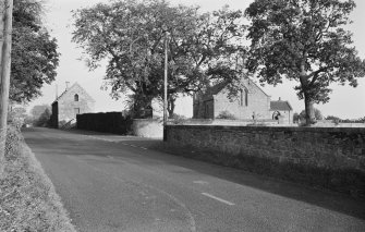 View of the tithe barn and church from the road.