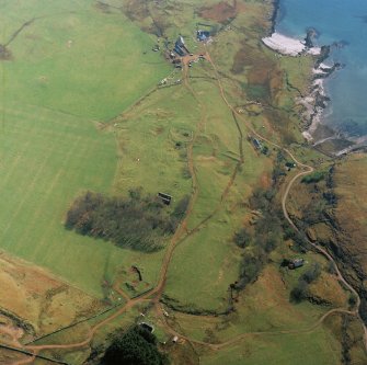 Oblique aerial view centred on the remains of the church with farmhouse, barn and farmsteading adjacent, taken from the NW.