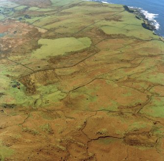 Oblique aerial view centred on the remains of the township and field-system with farmstead adjacent, taken from the NNE.