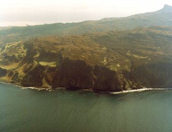 General oblique aerial view of the west side of Eigg with the fort in the foreground and the Sgurr fort beyond, taken from the NW.