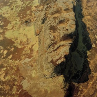 Oblique aerial view centred on the E end of An Sgurr and the remains of the fort, taken from the E.