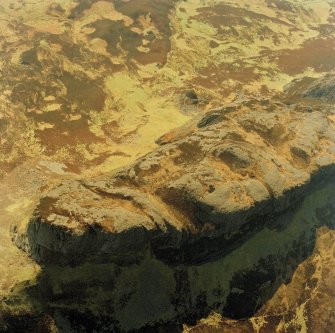 Oblique aerial view centred on the E end of An Sgurr and the remains of the fort, taken from the NNE.