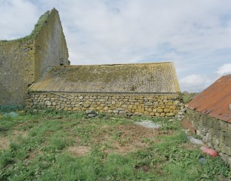 Single storey building to East of ruinous castle, view from South.