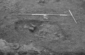 Excavation photograph : detail, yellow clay and cobbles in pit 400, looking west.