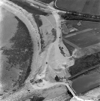 Oblique aerial view of bridge under construction and the site of Helmsdale Castle.