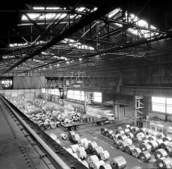 Interior.
View of overhead gantry crane loading steel coils onto lorry in despatch area.