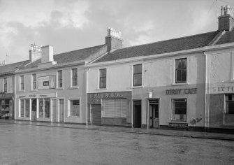 View of 28-38 Glasgow Street, Ardrossan, from NW, showing the Co-Op, Derby Cafe and Peter B Aitken butcher.