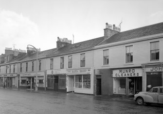 View of 50-60 Glasgow Street, Ardrossan, from W, showing Lipton's, the Co-Operative Drug Department, The Auto Shop and Munro Cleaners.