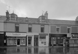 View of 47-53 Princes Street, Ardrossan, from SW, showing the premises of Cockburns dispensing chemist, Ministry of Labour and J N Macdonald & Co.
