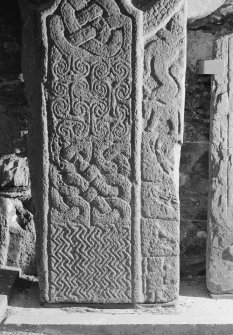 View of face A of cross-slab at Ardchattan, showing shaft of cross, and animals, musicians and warrior on the right of the cross-shaft.
 
