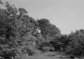 View of W range of Donibristle House stables through trees.