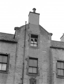 View of the skew gable incorporating chimney at the front facade of Hermits and Termits, 64 St Leonard's Street, Edinburgh, and showing the scrolled skewputts at either side.