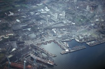 Oblique aerial view from NE of harbour at Greenock with part of Scott's Shipbuilding Yard.