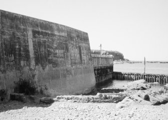 View of sea wall, rocky foreshore and sea.