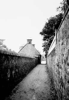 View from east of wall enclosing Cardy Net Works and rear of Cardy Cottage