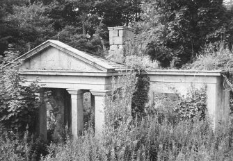 General view of delapidated overgrown lodge.