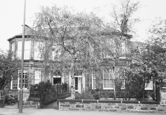 General view of the front facade of No. 15 and 17 partially obscured by a tree seen from the South South East.