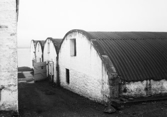 Lochindaal Distillery, Port Charlotte, Islay.
General view of warehouses from West.