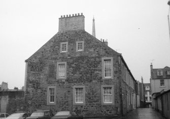 View of gable end of 20-22 Academy Street facing Fort Street, with top of Town Hall Steeple showing above roof line.