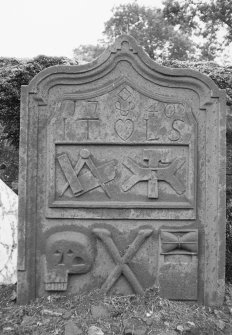 General view of gravestone commemorating I.T and L.S, 1740. Set-square axe and mill-rind, skull, crossed bones and hourglass.