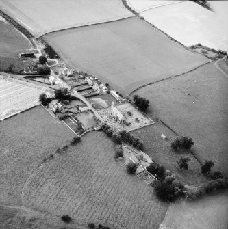 Oblique aerial view centred on church from SE.
