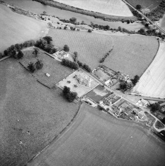 Oblique aerial view centred on church from NW.