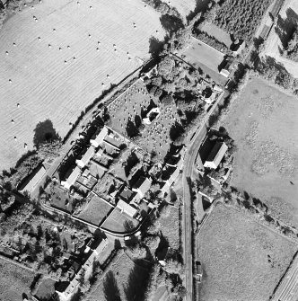 Oblique aerial view centred on the remains of the church and burial ground with old church and hotel adjacent, taken from the SW.