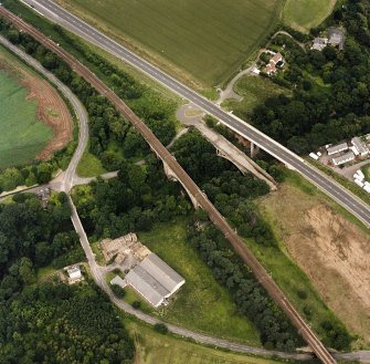 Oblique aerial view of Dunglass centred on bridges and a viaduct, taken from the S.
