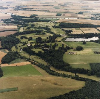 General oblique aerial view centred on the country house, stable, laundry, offices, museum and lake, taken from the NNW.
