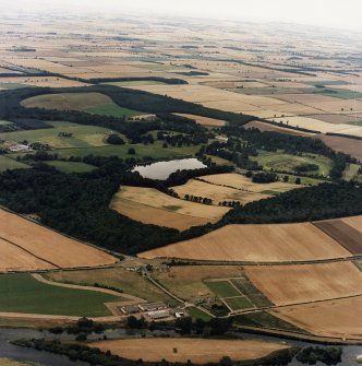General oblique aerial view centred on the country house, stable, laundry, offices, museum and lake, taken from the SW.