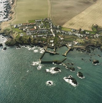 Oblique aerial view centred on the village and harbour, taken from the NE.