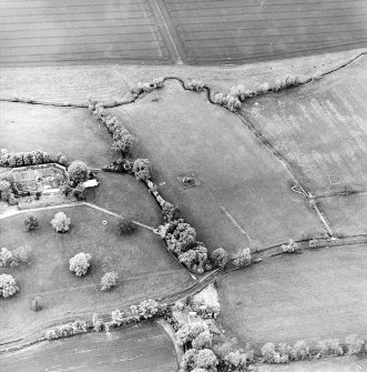 Oblique aerial view centred on the remains of the tower-house with cottage and walled garden adjacent, taken from the SSE.