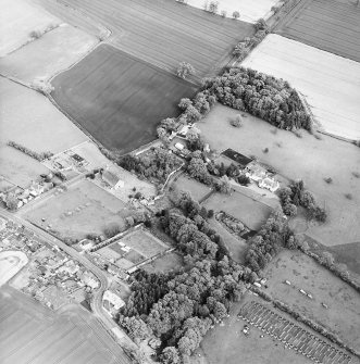 Oblique aerial view centred on the church, burial ground and walled garden, taken from the W.