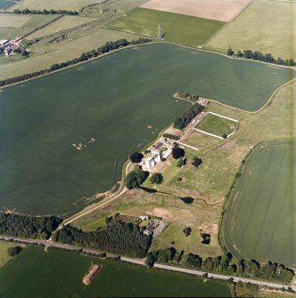Oblique aerial view centred on the tower house, with the coach house, stable and walled garden adjacent, taken from the SW.