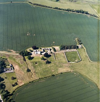 Oblique aerial view centred on the tower house, with the coach house, stable and walled garden adjacent, taken from the S.