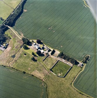 Oblique aerial view centred on the tower house, with the coach house, stable and walled garden adjacent, taken from the SE.