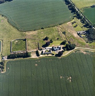 Oblique aerial view centred on the tower house, with the coach house, stable and walled garden adjacent, taken from the N.