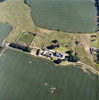 Oblique aerial view centred on the tower house, with the coach house, stable and walled garden adjacent, taken from the NNW.