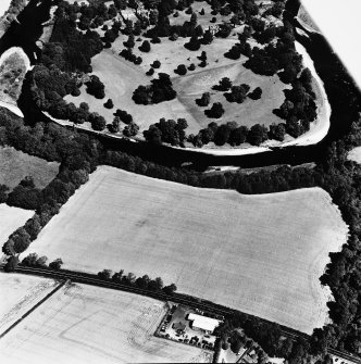Oblique aerial view from SSW, centred on the cropmarks of a rectilinear settlement, and with Dryburgh Abbey, a dovecot and a country house visible in the upper half of the photograph.