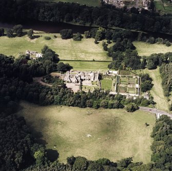 Oblique aerial view of Abbotsford centred on the country house with tea room, gardens and stables adjacent, taken from the SE.