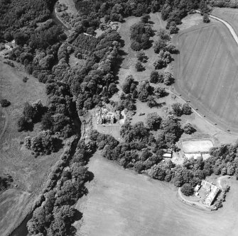 Oblique aerial view centred on the castle, tower-house and country house with the stables, tower and walled garden adjacent, taken from the SE.