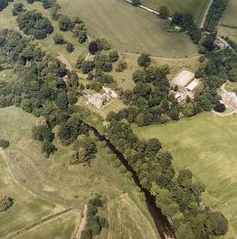 Oblique aerial view centred on the castle, tower-house and country house with the stables, tower and walled garden adjacent, taken from the S.