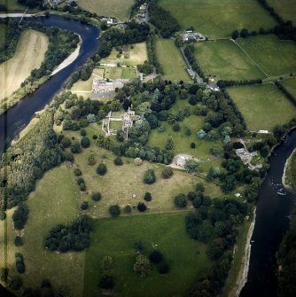 Oblique aerial view centred on the remains of the abbey, the country house and dovecot with the hotel and stables adjacent, taken from the S.