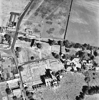 Oblique aerial view from the SW, centred on the remains of the Abbey. The cropmarks of buildings are visible in the top centre half of the photograph.