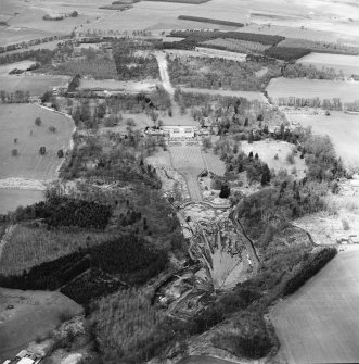 Oblique aerial view centred on the drained formal pond within Mellerstain House garden with country house and stables adjacent, taken from the SE.